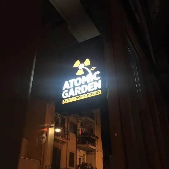 Fachada nocturna de Atomic Garden en Palma con el cartel iluminado Beer, Rock and Movies